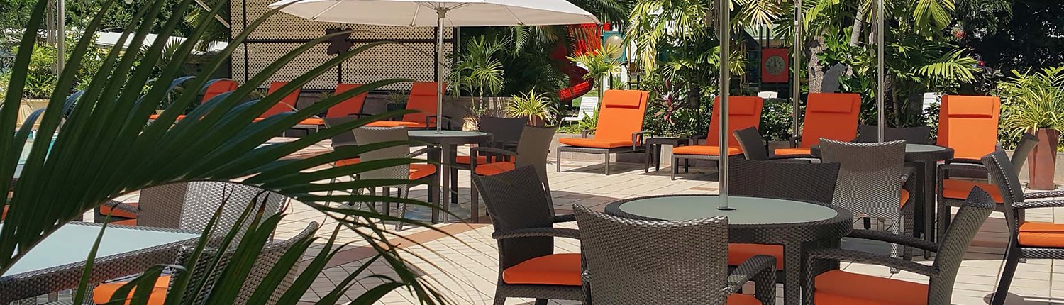 outdoor patio tables, chairs, and lounge chairs with orange cushions