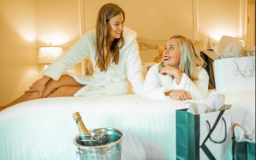 two smiling women in bathrobe in a hotel room 