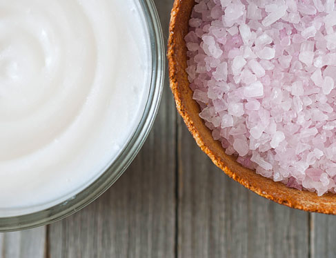 Bowl with lotion next to bowl of bath crystals