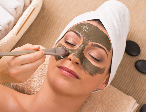 Woman at spa getting mud mask applied