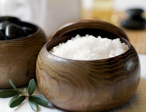 Two wooden bowls with bath salts & massage rocks