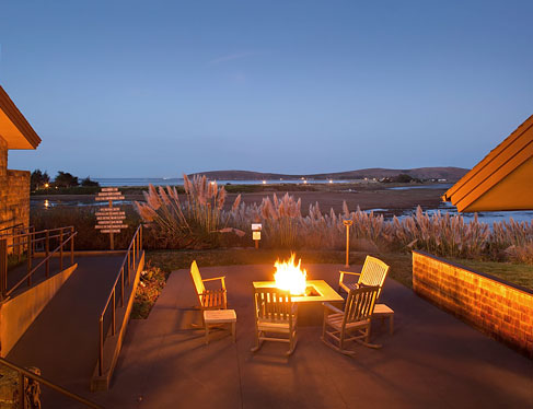 Outdoor seating area at night with fire pit lit up