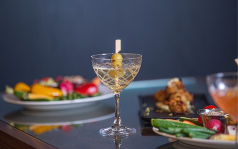 dry martini with plates of food surrounding the glass