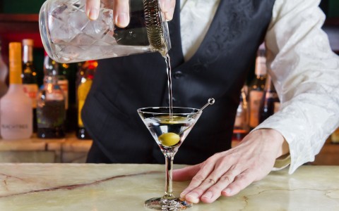 a bartender pouring a martini