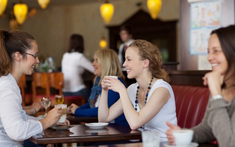 a group of women enjoying coffee in a restaurant 