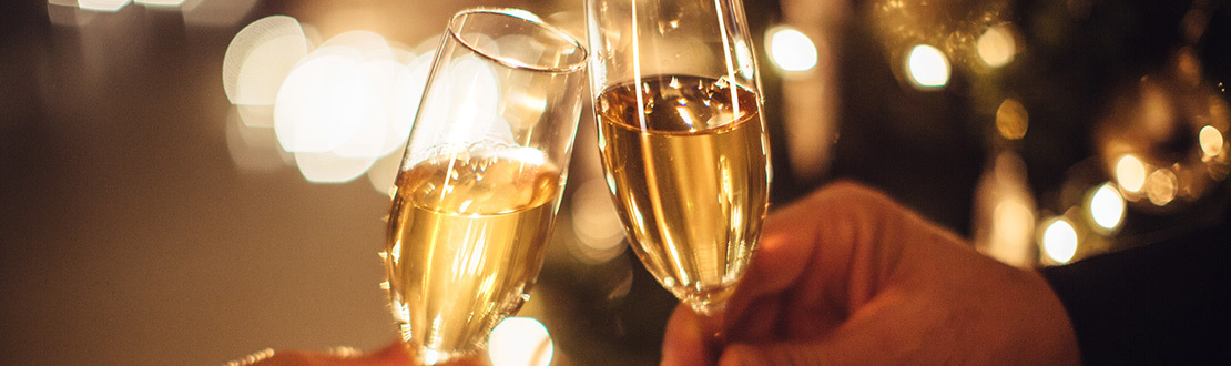 two people cheers champagne glasses