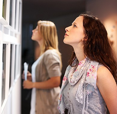 Two women looking at pictures on a wall