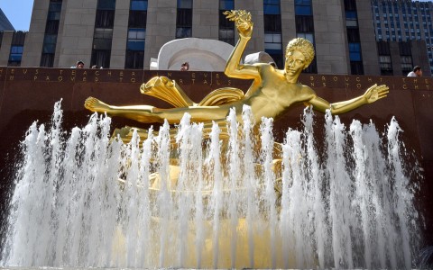 gold sculpture above water fountain rockefeller center