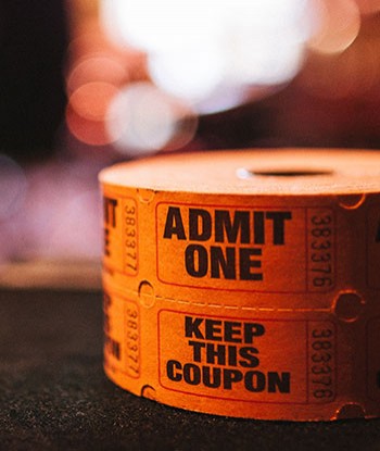 close up of two orange ticket rolls that say Admit One