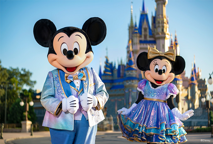 Mickey and Minnie Mouse standing in front of the castle