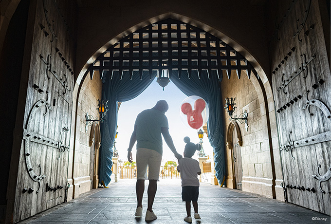 Father and child walking together with a balloon 