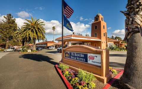 Street and entrance sign to El Rancho Inn & Suites with hotel in the background
