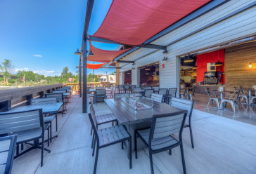 Zpizza and tap room outdoor seating area with dining tables and chairs