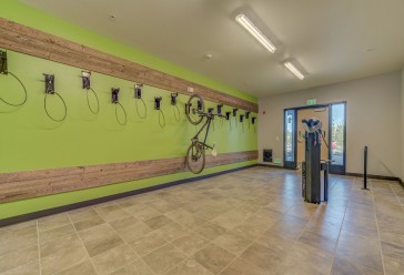 open space bike room with a bright green wall for hanging bicycles