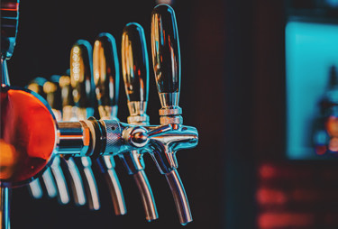 A close up of the draft taps with low lighting.