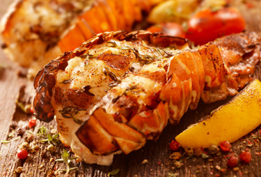 Grilled lobster tails served with lemon.