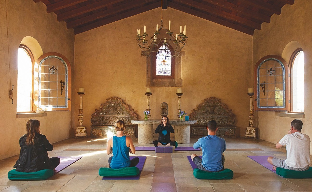 three people meditating in chapel