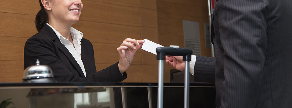 Woman giving man key to room