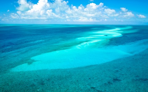 Aerial view of the beautiful ocean with different kinds of blue