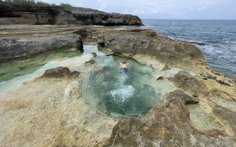 View of a natural jacuzzi and some large rocky mountains at Eleuthera 