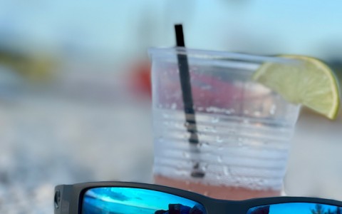 close up of sunglasses with a cocktail