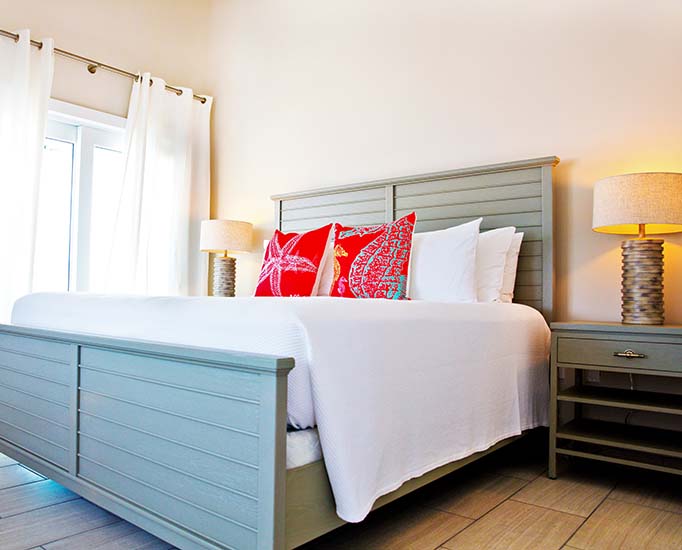 Internal view of a Cottage room with a grey and white comfortable bed