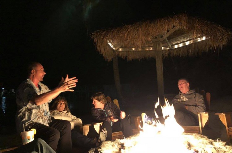 two couples talking by the fireplace