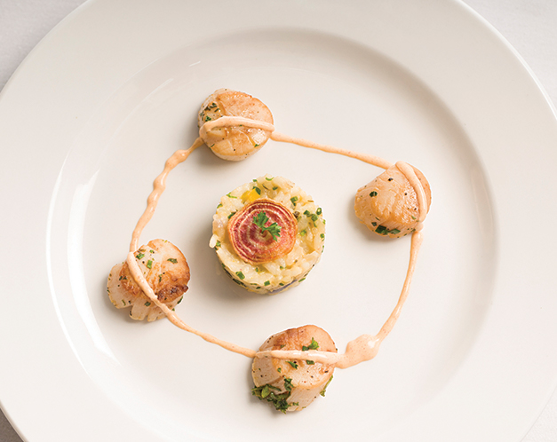 nicely decorated plate of scallops and a ball of rice