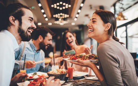 group of friends at a restaurant eating laughing 
