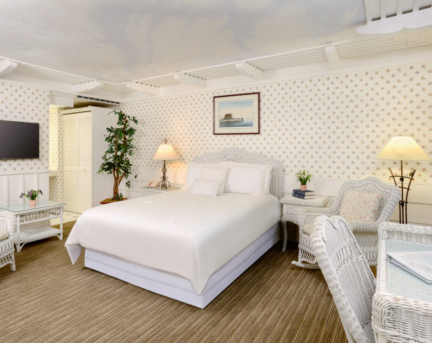 guest room with white furniture and white bed sheets
