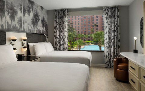double queen beds with a view of the pool and pink buildings