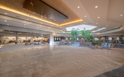 big lobby with palm trees and seating areas
