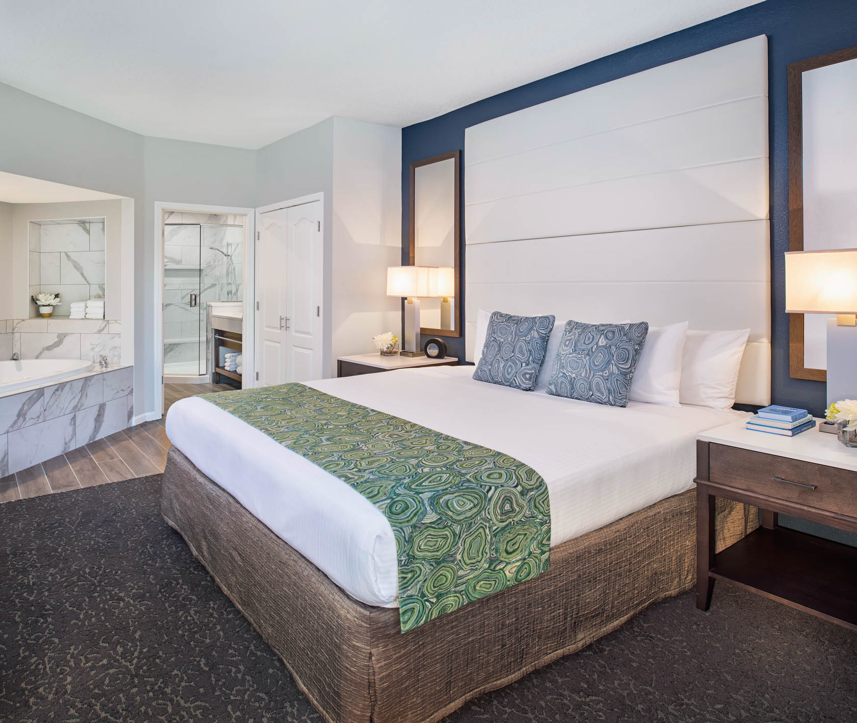 king bed with adjoining jacuzzi and bathroom with walk in marble shower