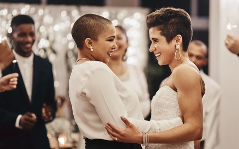 two brides looking at each other while embracing 
