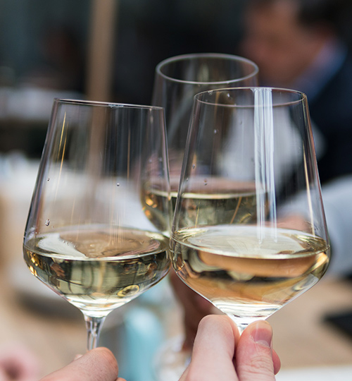 clinking white wine glasses together