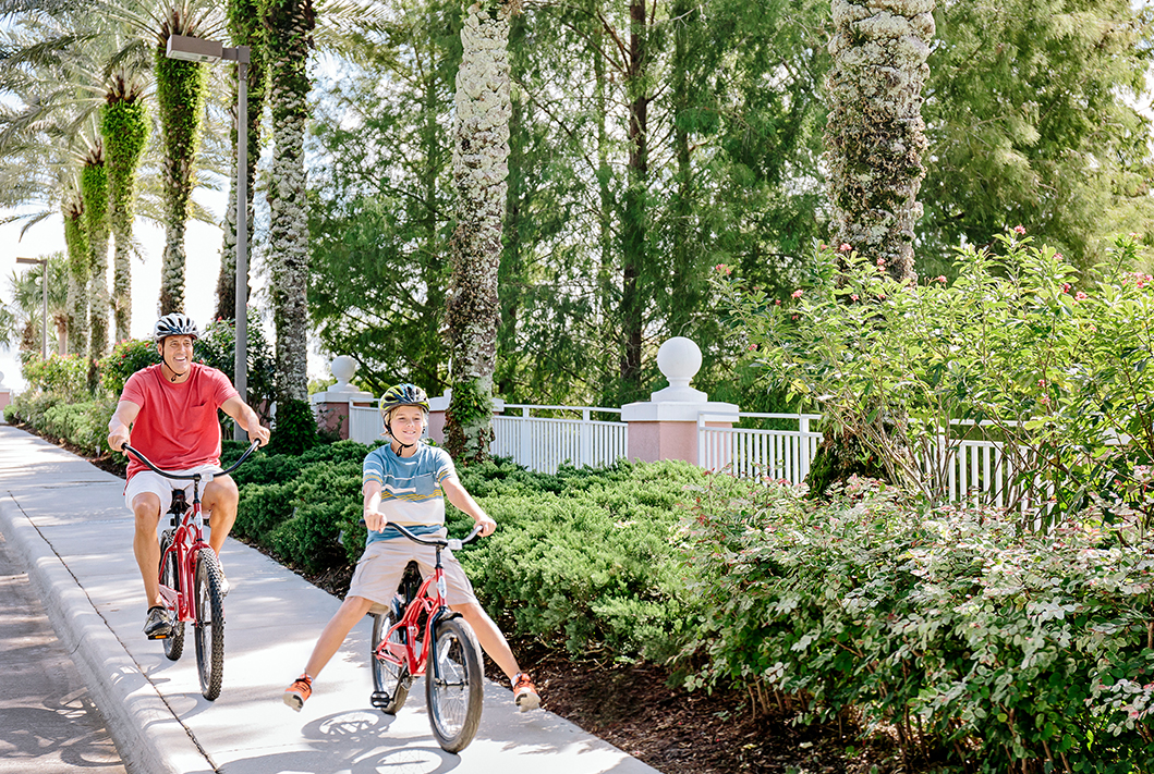 dad and child riding bikes on a sidewalk 