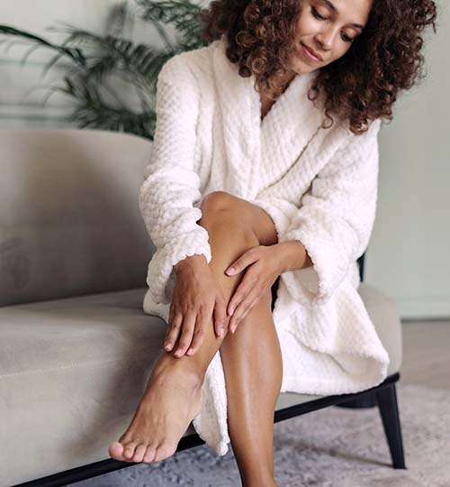 woman sitting in a chair and rubbing her leg