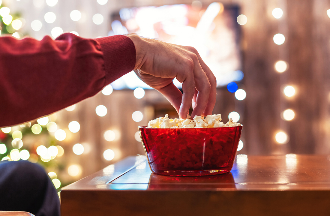 someone eating popcorn watching a christmas movie