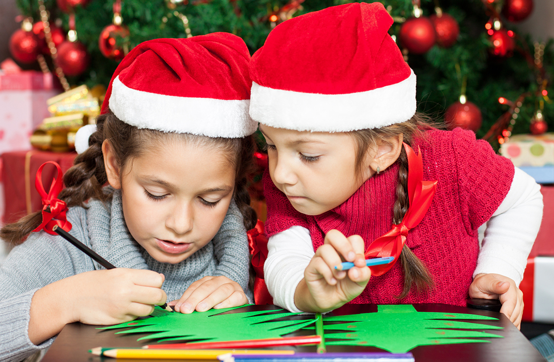 kids crafting christmas trees with santa hats on