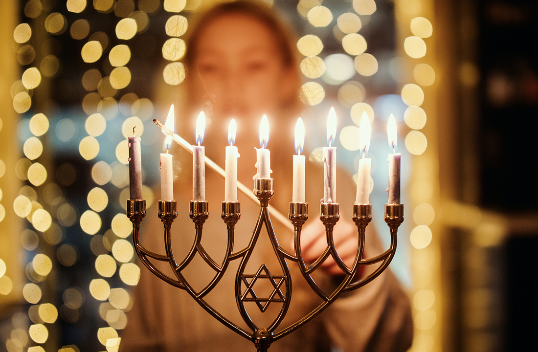 someone lighting a menorah