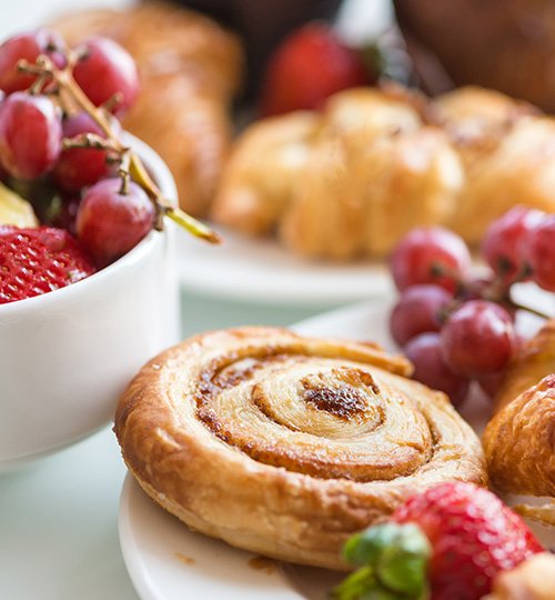 close up of a pastry with fruit around it on a white plate