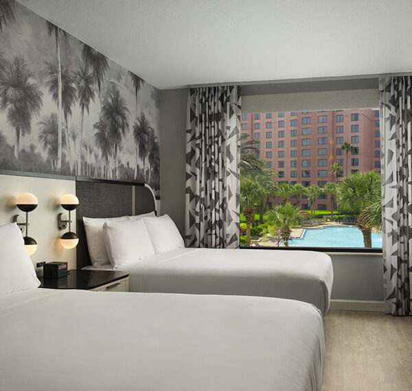 double queen beds with a view of the pool and black and white curtains