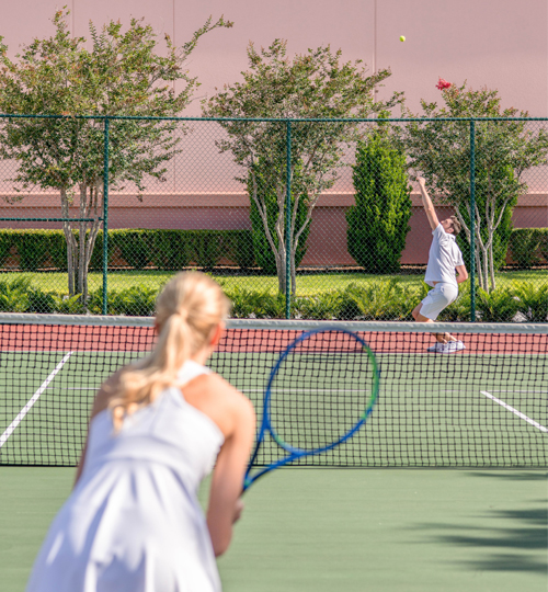 man and woman playing tennis on a tennis court