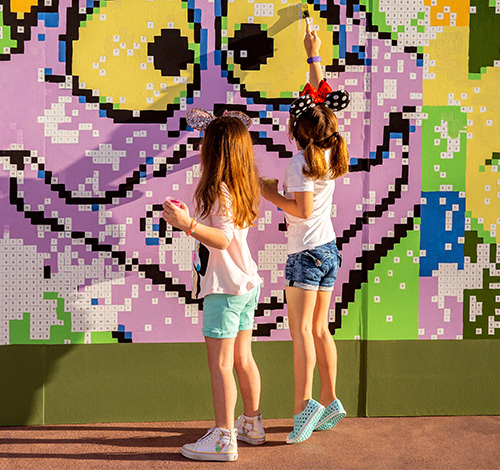 girls holding paint in a Disney park activity