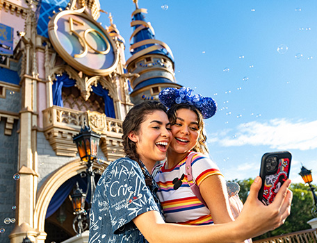 Young lady with girl taking a selfie in front of castle