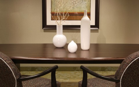 white vases on wooden table with two chairs