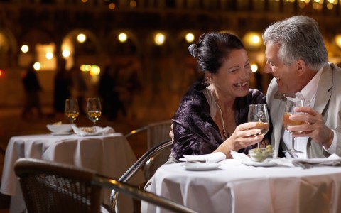 couple at table holding wine glasses