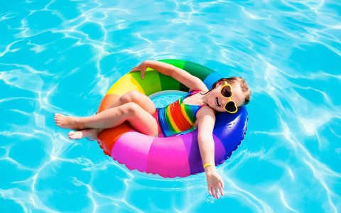 little girl sitting on a float in the pool