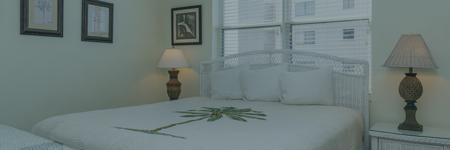 Casa Play Resort Bayview Suite King bed with palm embroidery on the bedspread