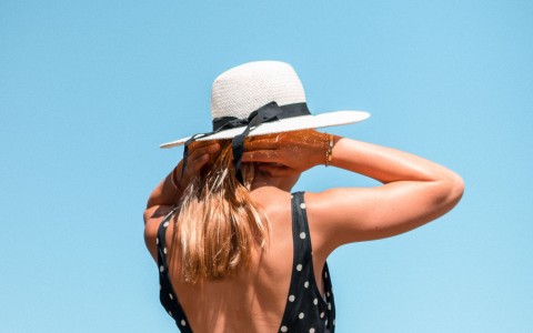 woman in a polka-dot swim suit and white hat